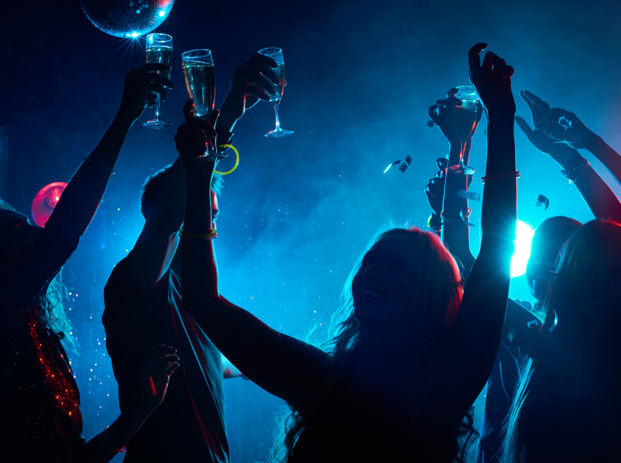 Group of people partying indoors under dark disco lights